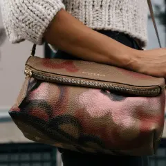 Torba Burberry z motywem moro, przykład brytyjskich marek odzieżowych, noszona przez kobietę w swetrze.