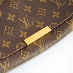 Złota blaszka z napisem "LOUIS VUITTON PARIS" na brązowej torebce z monogramem. Chcesz sprawdzić numer seryjny?