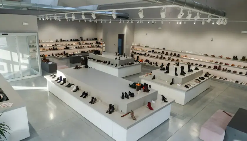 Nowoczesny salon obuwniczy z bogatym asortymentem, od eleganckich szpilek po stylowe botki. Wiele par butów, w tym te z kolekcji agl, czeka na klientów.