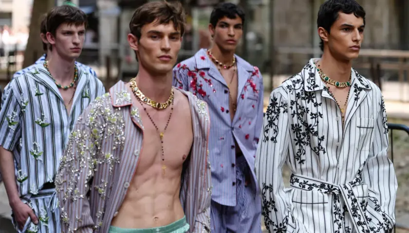 Mężczyźni w piżamach w stylu gabbana, ozdobionych kwiatami i cekinami, prezentują się na wybiegu.