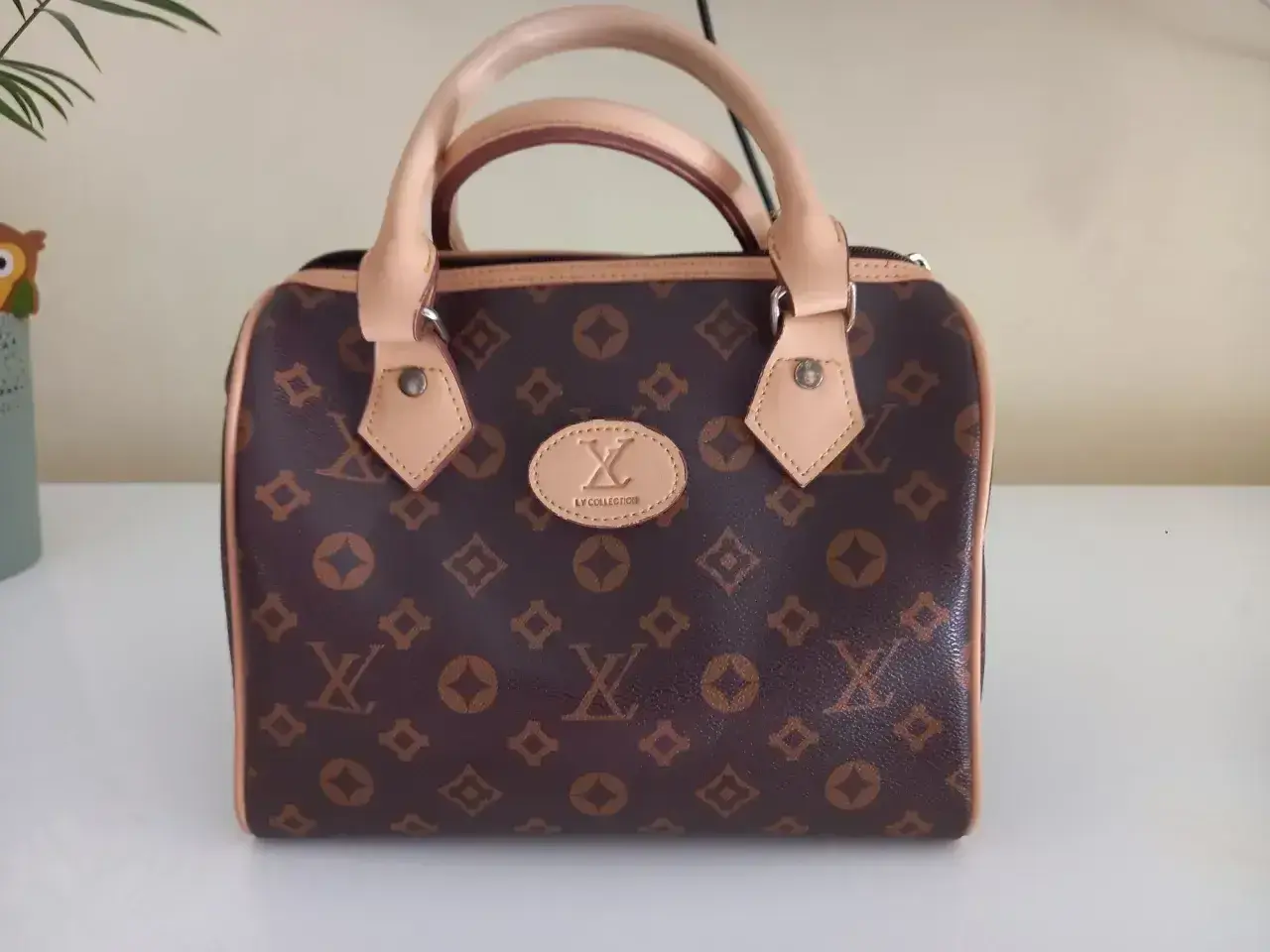 Elegancka brązowa torebka z monogramem, przypominająca luksusowe marki torebek. Idealna na co dzień i specjalne okazje.
