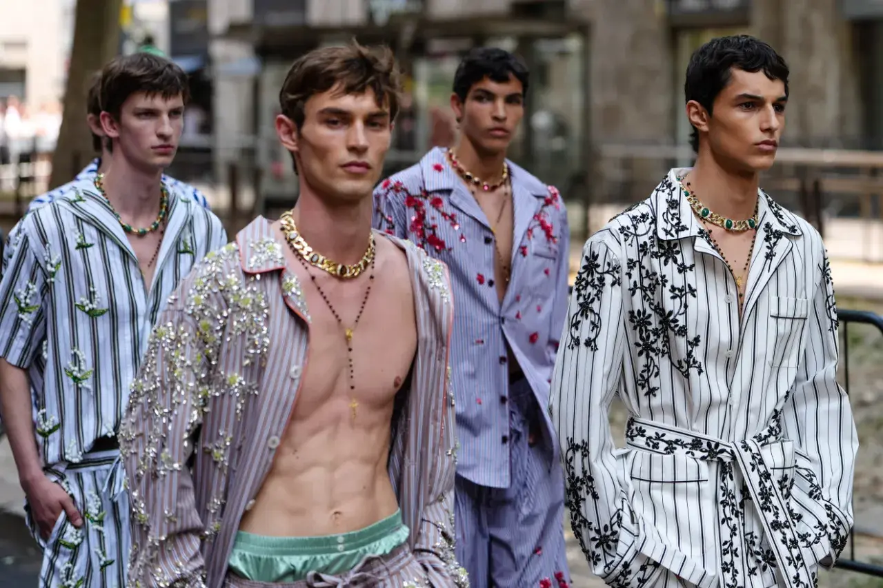 Mężczyźni w piżamach w stylu gabbana, ozdobionych kwiatami i cekinami, prezentują się na wybiegu.
