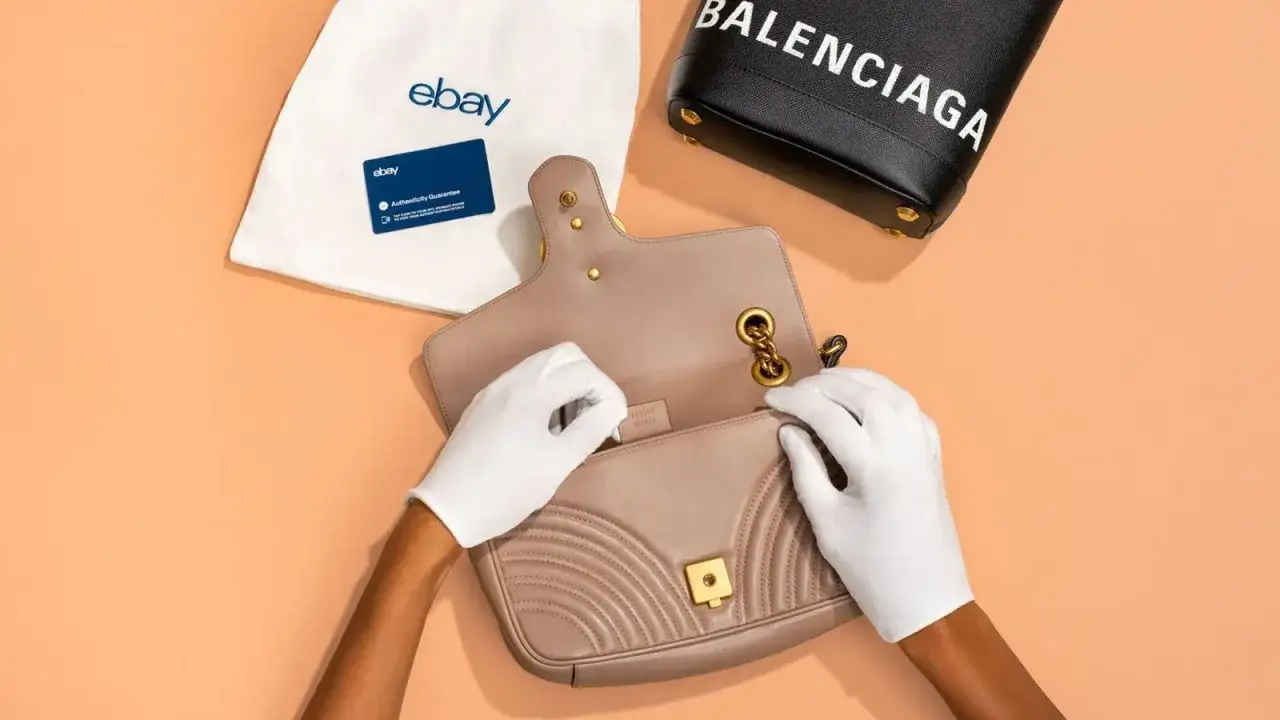 Ręce w białych rękawiczkach sprawdzają torebkę Gucci, obok torba eBay z kartą gwarancji autentyczności i torebka Balenciaga.